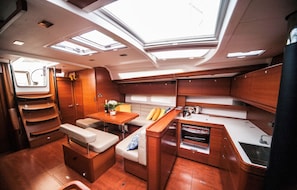 A compact, well-lit interior with a kitchenette, seating area, and skylights. - Sun-Kissed Sailing Adventure in Sibenik, Croatia (Primošten)