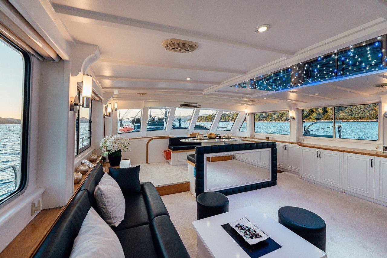 Un intérieur moderne avec un canapé, une table à manger et un coin cuisine, le tout à bord d’un bateau.