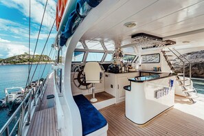 A yacht's deck with a steering wheel, a bar area, and a view of the sea. - Sun-Kissed Sailing Adventure in Split-Dalmatia, Croatia (Marina)