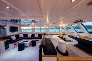 A modern yacht interior with a seating area, a control panel, and large windows offering a view of the water. - Sun-Kissed Sailing Adventure in Split-Dalmatia, Croatia (Marina)