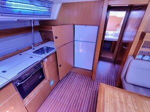A compact kitchen with a sink, stove, and refrigerator. - Sun-Kissed Sailing Adventure in Zadar, Croatia (Bibinje)