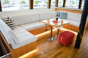 Ein modernes Interieur mit einer Couch, einem kleinen Tisch und einem roten Hocker.