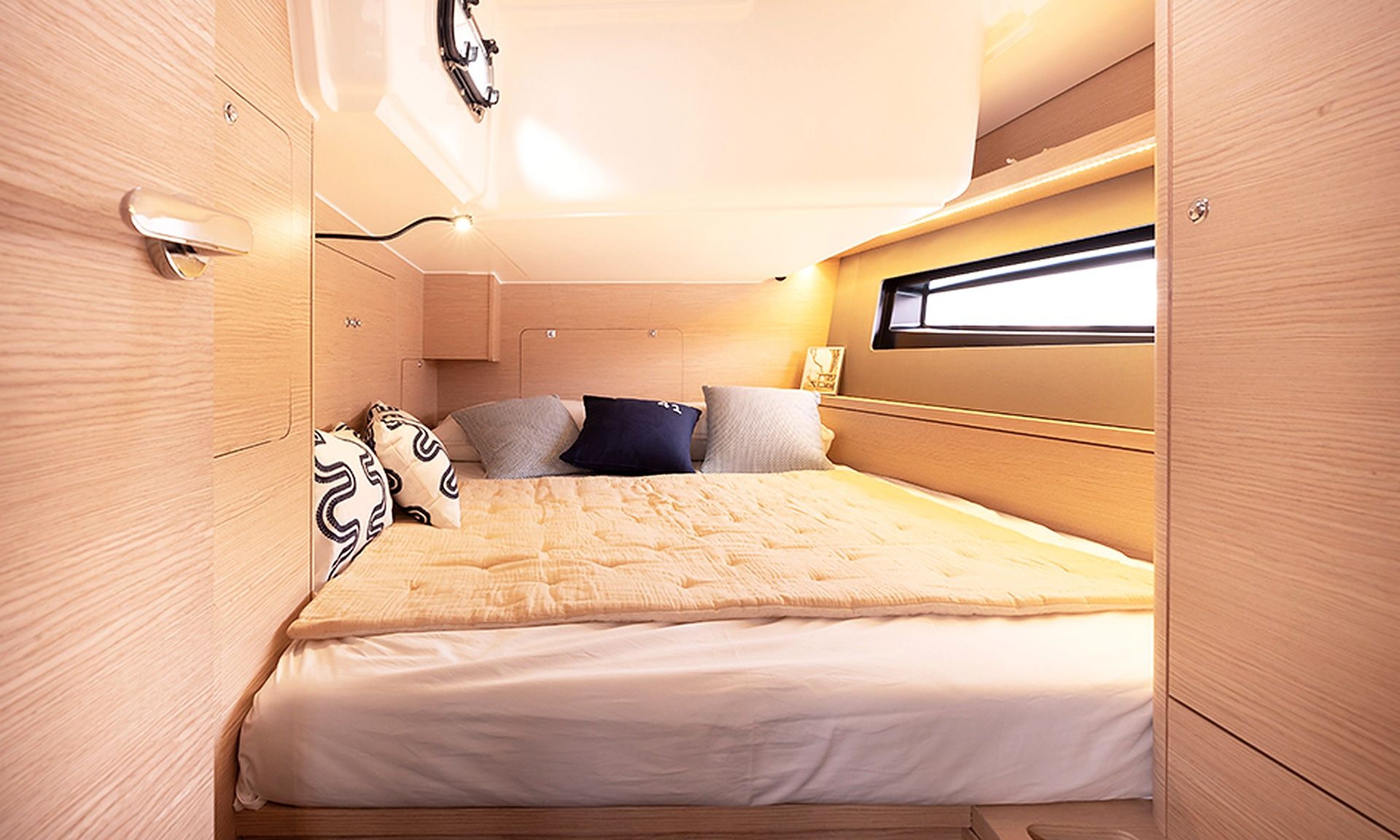 Un dormitorio pequeño y bien iluminado con cama, almohadas y ventana.