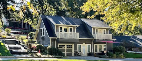 A two-story house with a front porch, a garage, and a driveway.