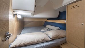 A compact, well-lit cabin with a bunk bed, a small desk, and a storage cabinet. - Sun-Kissed Sailing Adventure in Islas Sarónicas (Alimos)