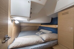 Ein kleines, helles Quartier mit Etagenbett, Schreibtisch und Stauraum.