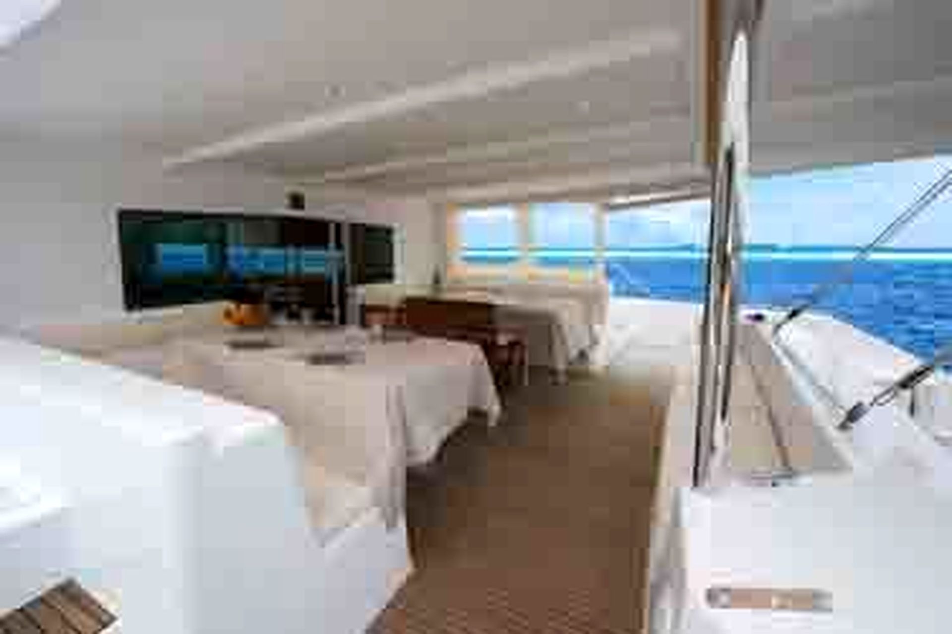 A room with a bed, a television, and a window overlooking the sea.