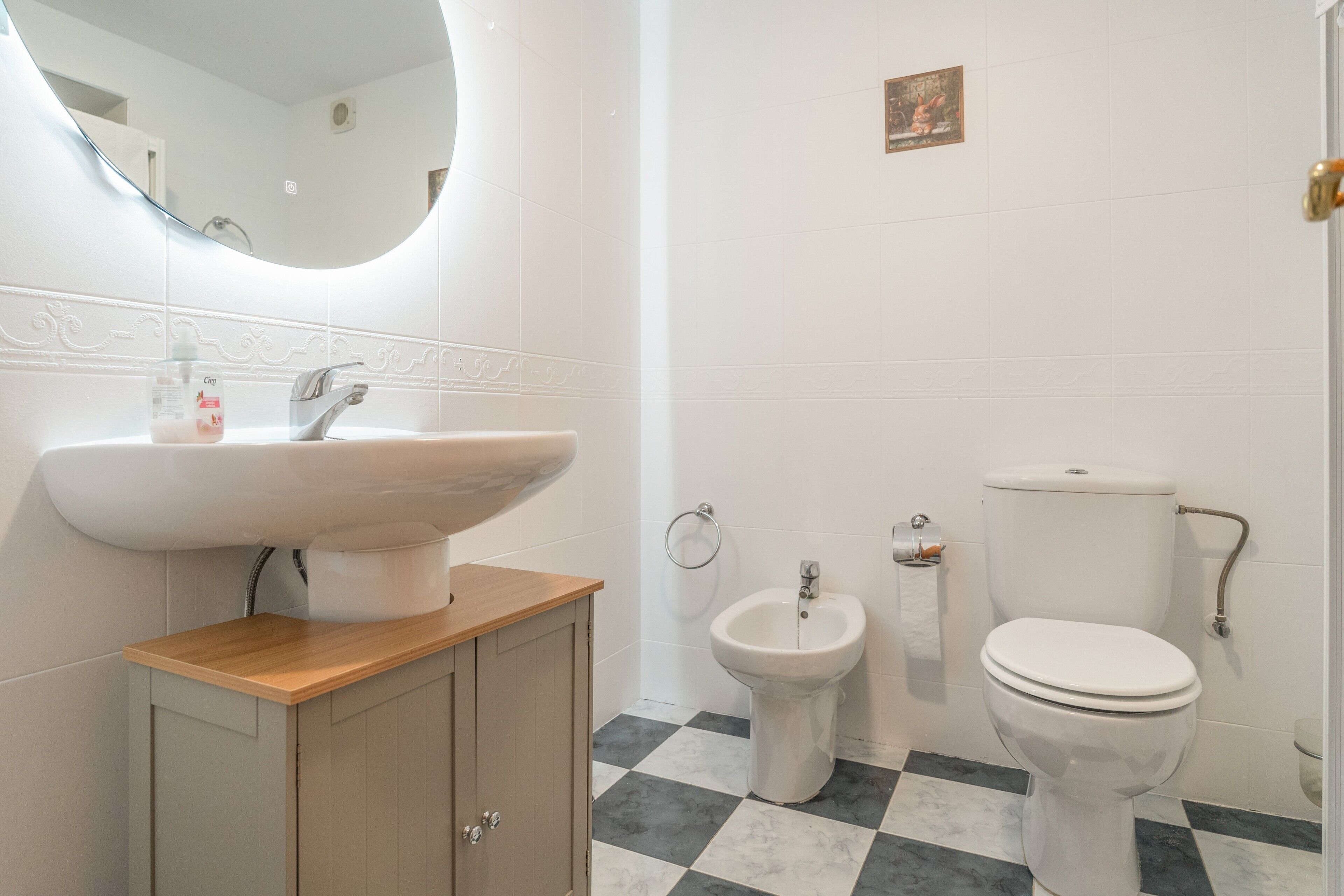 Un baño con lavabo, bidé, inodoro y espejo.