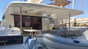 Um barco chamado 'Bella Barca' com casco branco, área de convés coberta e o logotipo 'FONTAINE PAJOT' na lateral.