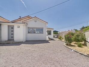 A residential property with a gravel driveway, a white exterior, and a small garden with pink flowers. - House for 6, garden, 30m from the sea (La Plaine-sur-Mer)