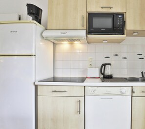 A compact kitchen with a Brandt refrigerator, a Samsung microwave, a coffee maker, and a dishwasher. - L'Amirauté   4/5 pers I Piscine I Parking inclus (Les Sables-d´Olonne)