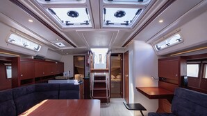 A compact interior with a central table, seating, skylights, and a small kitchenette. - Sun-kissed Sailing Adventure in Split-Dalmatia, Croatia (Seget Donji)