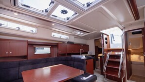 A compact interior with a dining area, cushioned seating, a kitchen, and skylights. - Sun-kissed Sailing Adventure in Split-Dalmatia, Croatia (Seget Donji)