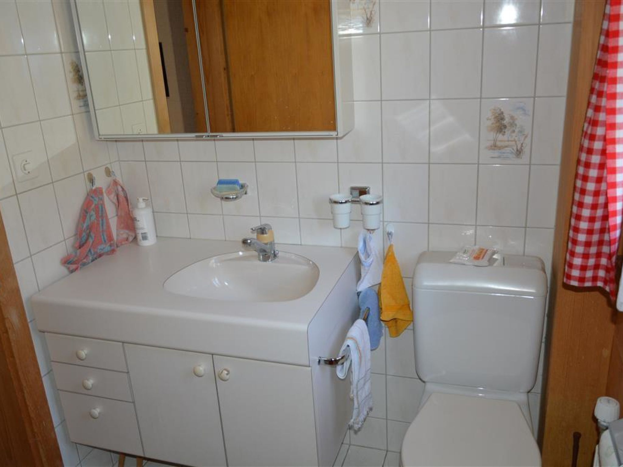 Ein Badezimmer mit Waschbecken, Spiegel, Toilette und Handtuchhalter.