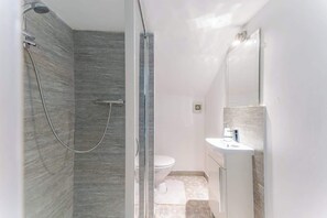 Une salle de bain avec une douche, des toilettes et un lavabo.