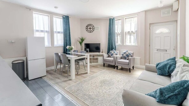A modern living room with a sofa, TV, dining table, and chairs. - Central Bristol Luxury Apartment w/ Fast WiFi, (Redfield)