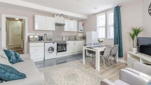 A modern apartment with a kitchen, dining area, and living room. - Central Bristol Luxury Apartment w/ Fast WiFi, (Redfield)