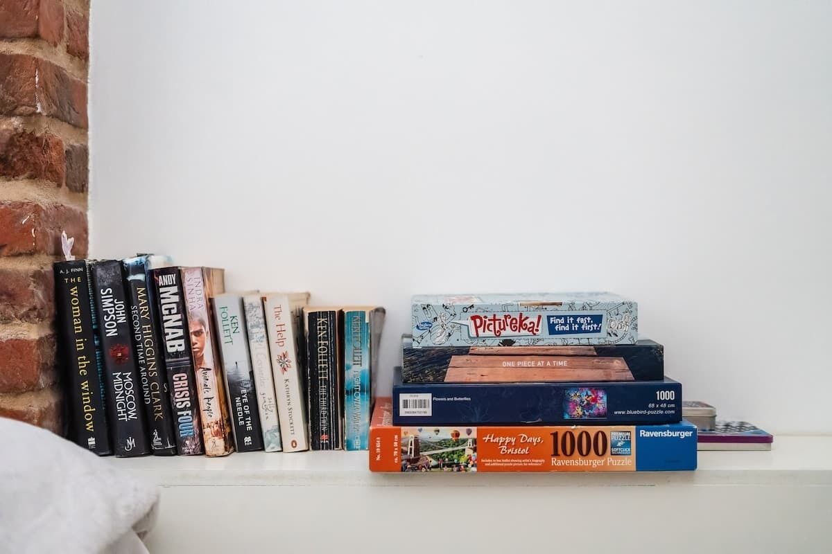 Una estantería con varios libros y juegos de lógica.