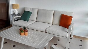 A living room with a sofa, a coffee table, and a decorative wall piece. - Luméa Apartment (Les Trois-Îlets)