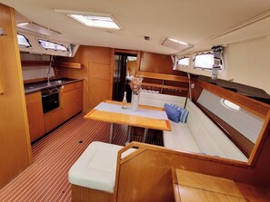 A compact galley with a stove, sink, and a small table with a bottle. - Sun-Kissed Sailing Adventure in Zadar, Croatia (Bibinje)