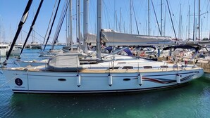 A sailboat docked at a marina with multiple masts and other boats in the background. - Sun-Kissed Sailing Adventure in Zadar, Croatia (Bibinje)