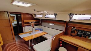 A compact galley with a wooden table, bench seating, and a control panel. - Sun-Kissed Sailing Adventure in Zadar, Croatia (Bibinje)
