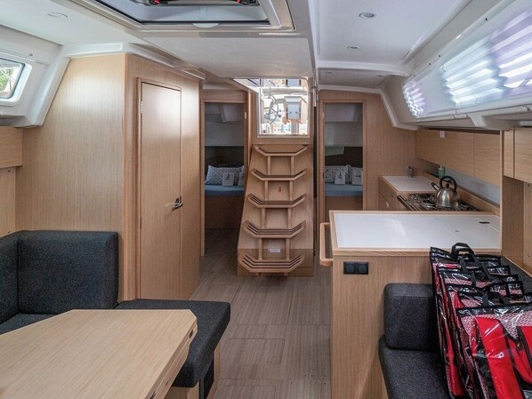 A compact RV interior with a kitchenette, seating area, and a small sleeping space. - Sun-Kissed Sailing Adventure in Zadar, Croatia (Zadar)