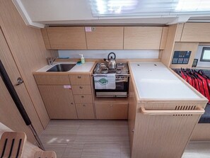 Una kitchenette compacta con pileta, estufa y alacenas.