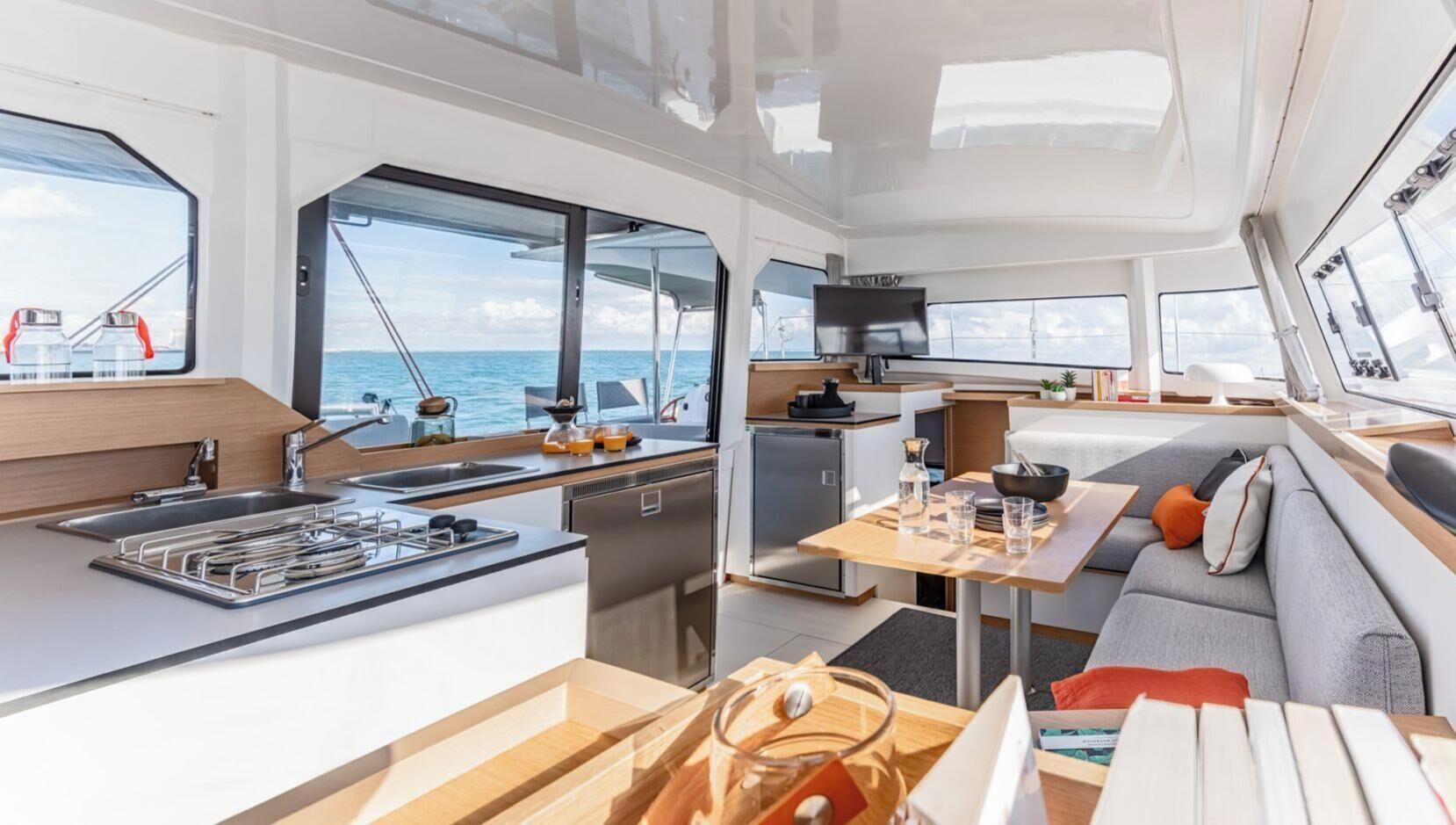 Interior moderno de un yate, con cocina, comedor y zona de estar.