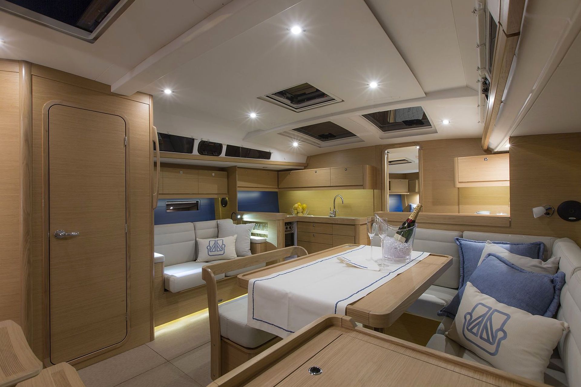 A compact, well-lit interior with a dining area, seating, and a kitchenette.