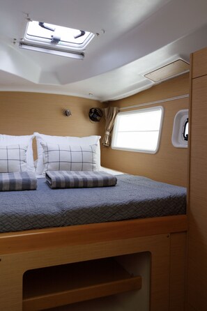 Ein kompaktes Wohnmobil-Interieur mit Etagenbett, Dachfenster und kleinem Fenster.