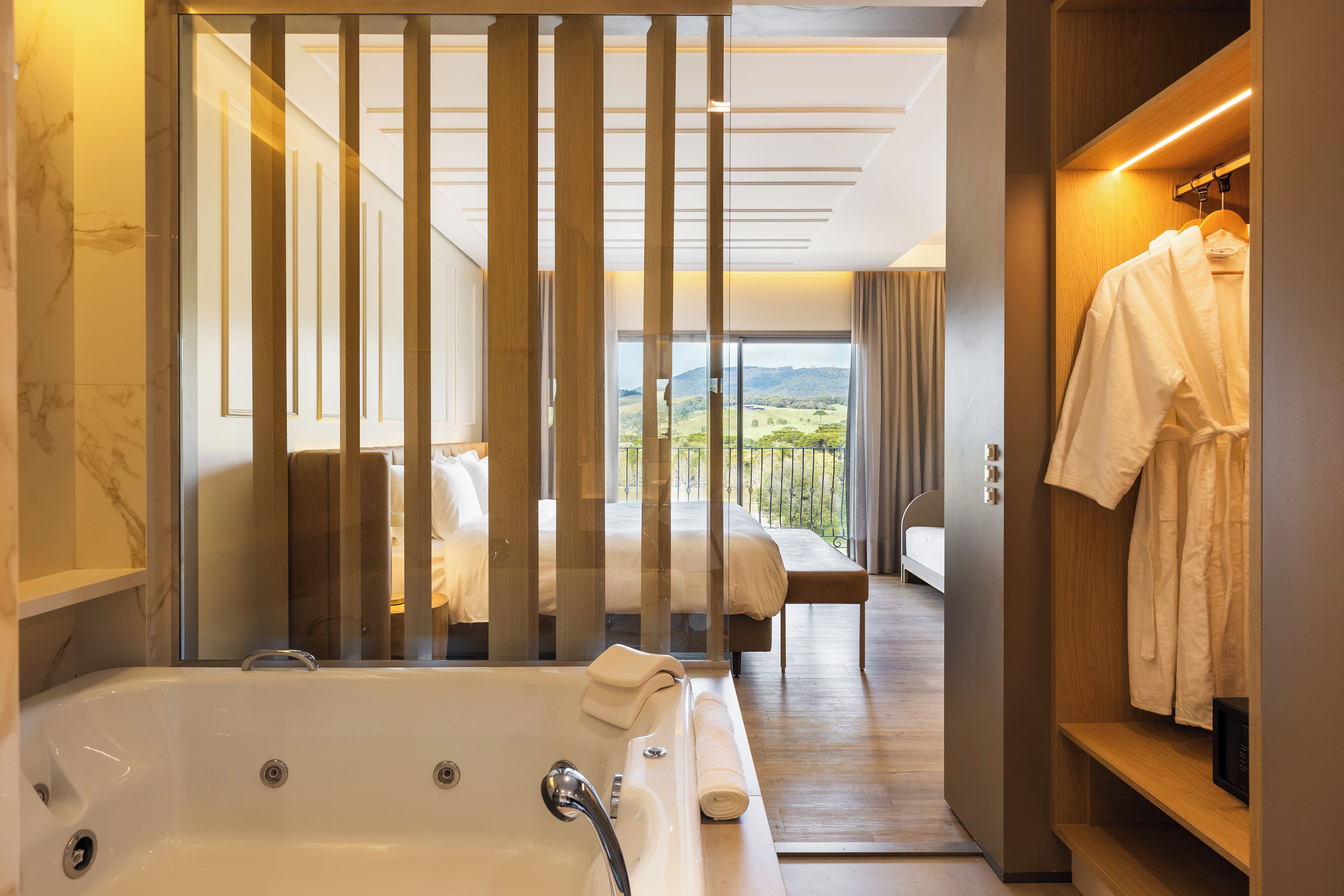 Un baño moderno con bañera, ducha y tocador. Una ventana grande ofrece vistas al exterior.