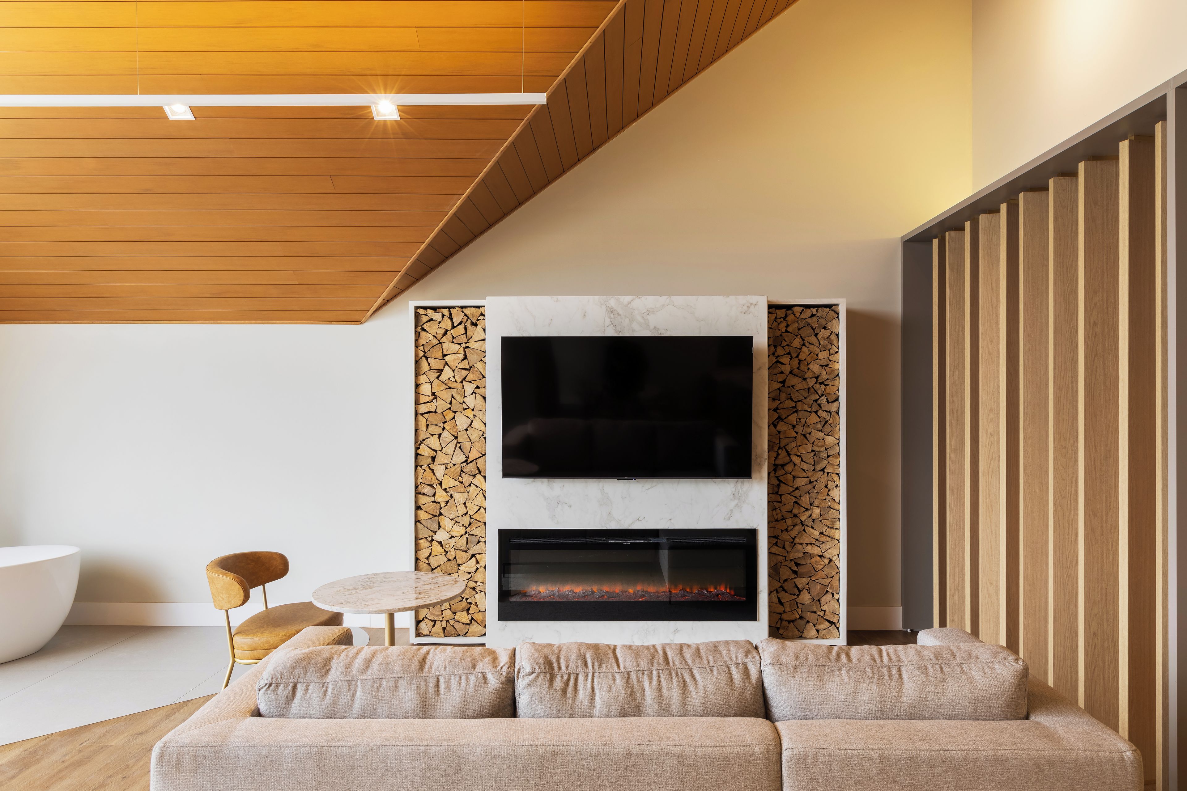 Una sala de estar moderna con chimenea, un sofá y una televisión.