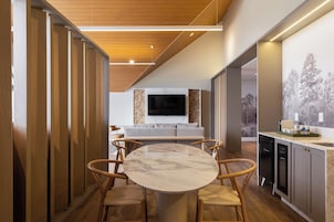Uma cozinha moderna com mesa de mármore redonda, cadeiras de madeira e televisão embutida.