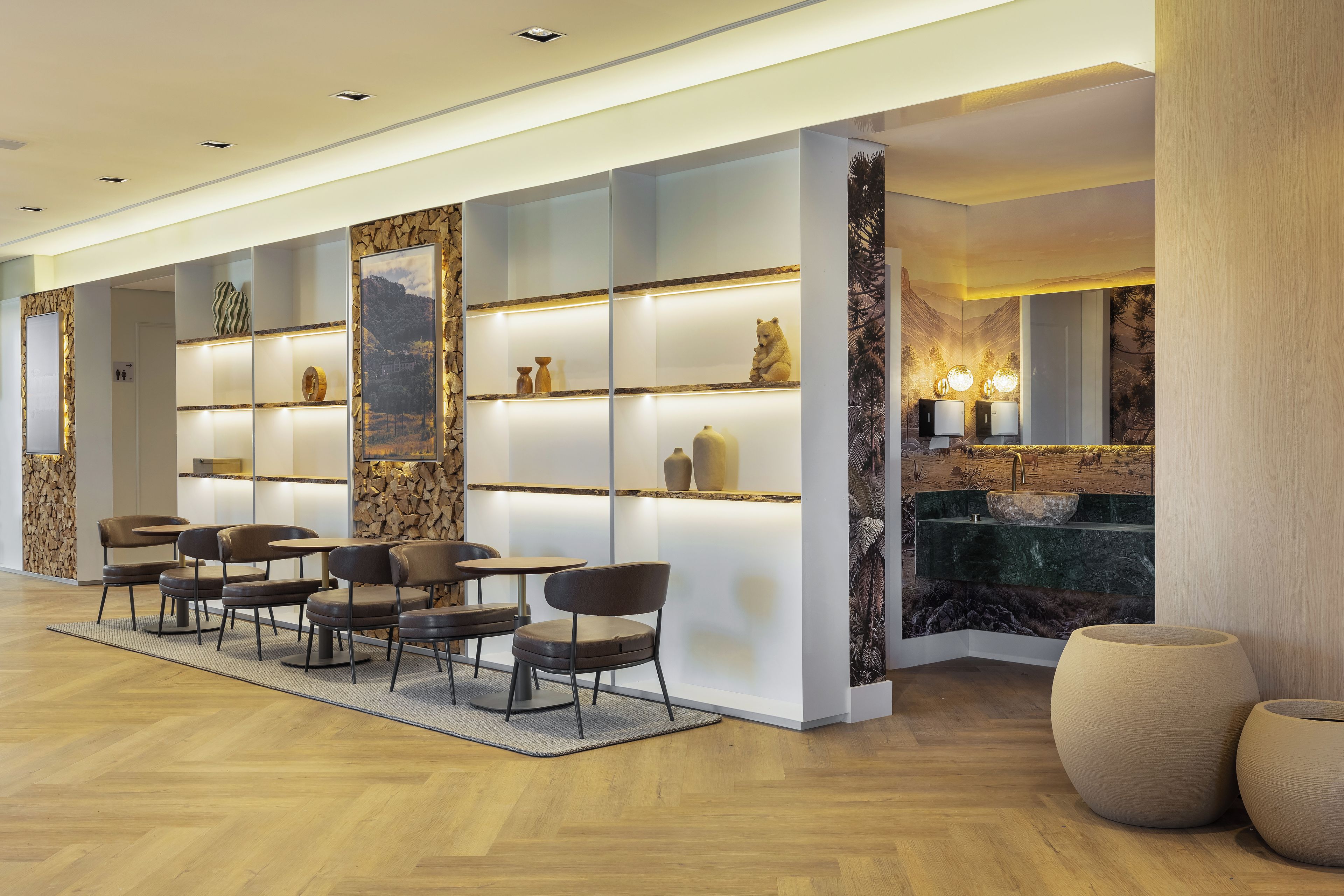 A modern hotel lobby with a reception desk, seating area, and decorative wall panels.