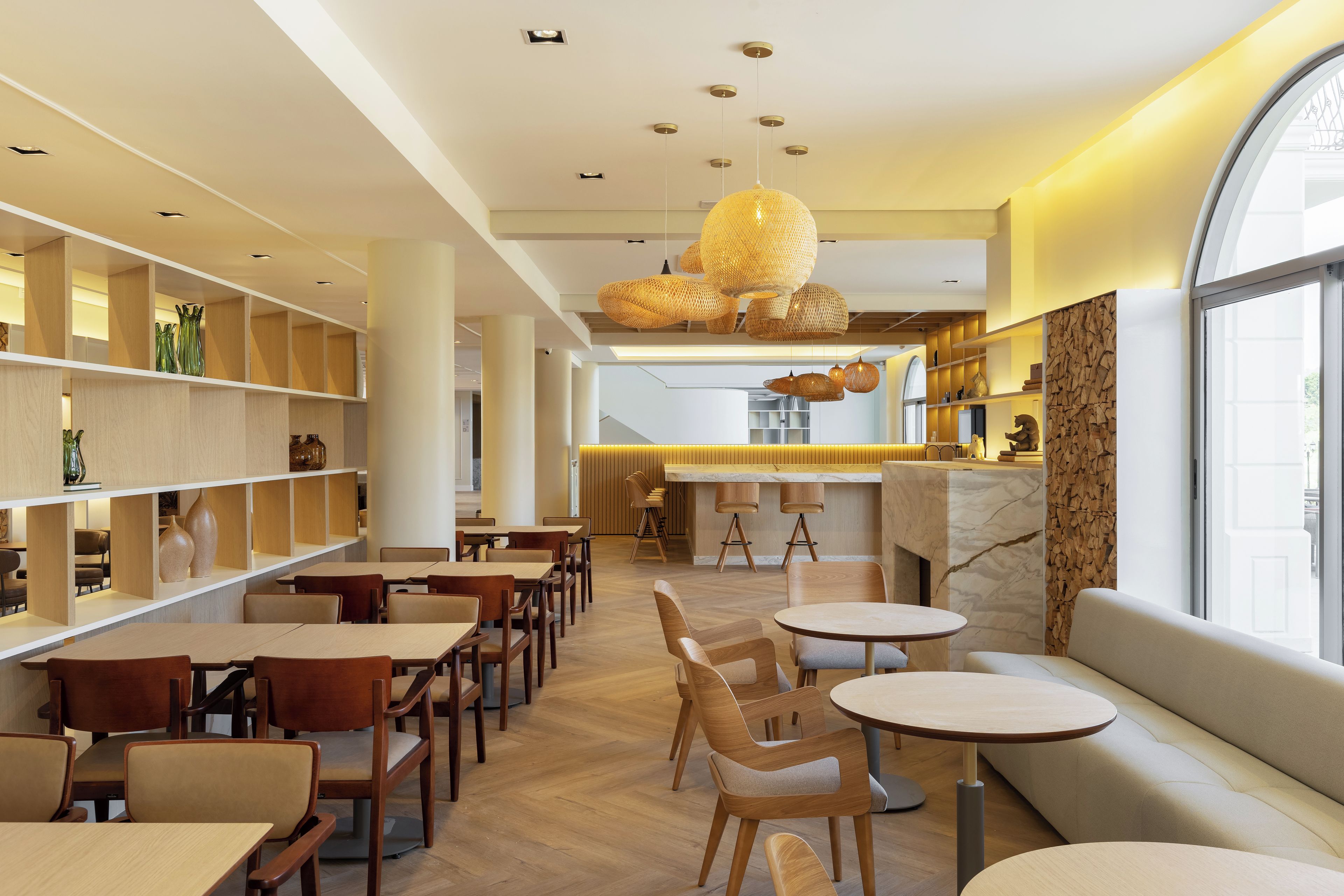 Un interior moderno con muebles de madera, una zona de estar central y una barra.