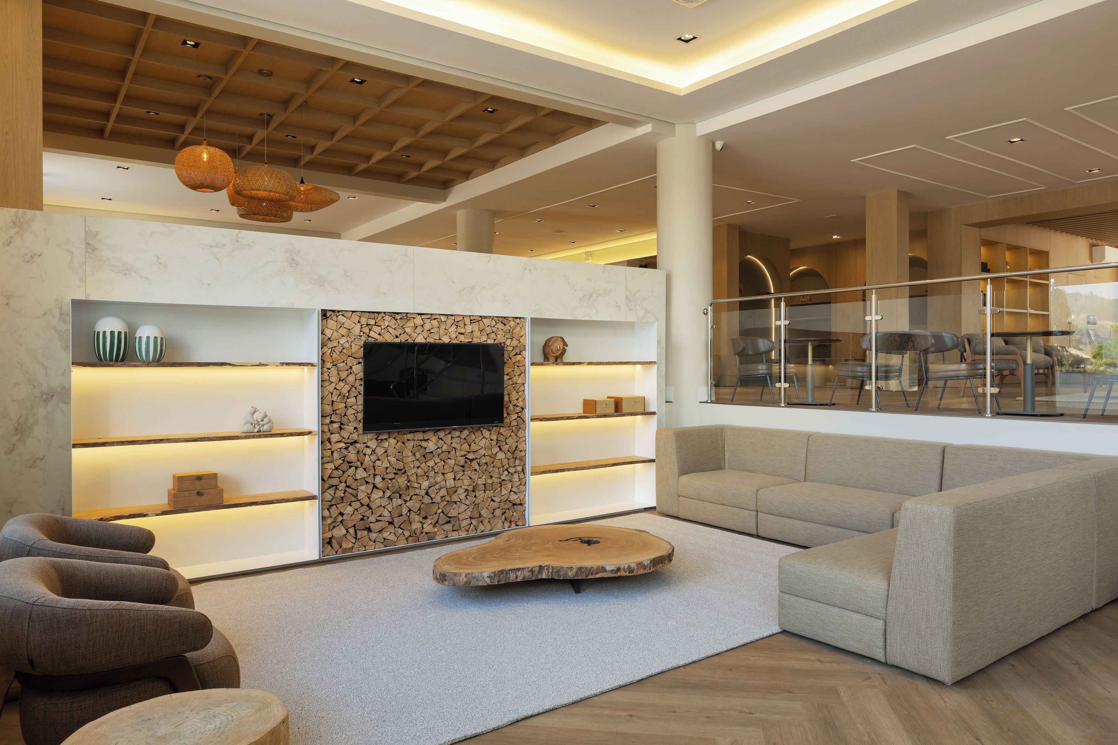 Una sala de estar moderna con chimenea, zona de estar y un ventanal grande que da a un comedor.