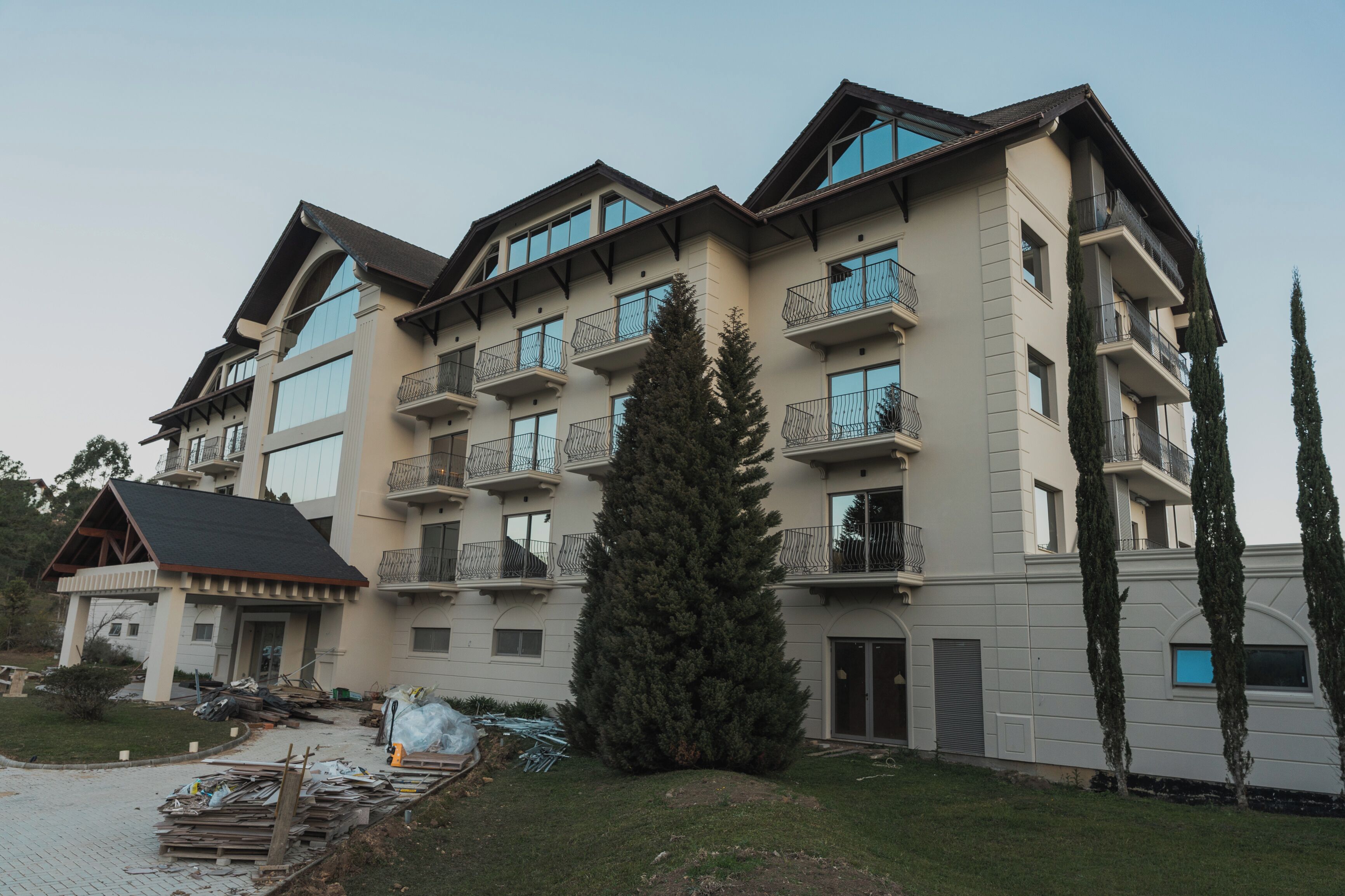 A multi-story building with balconies and a ski lift visible in the background.