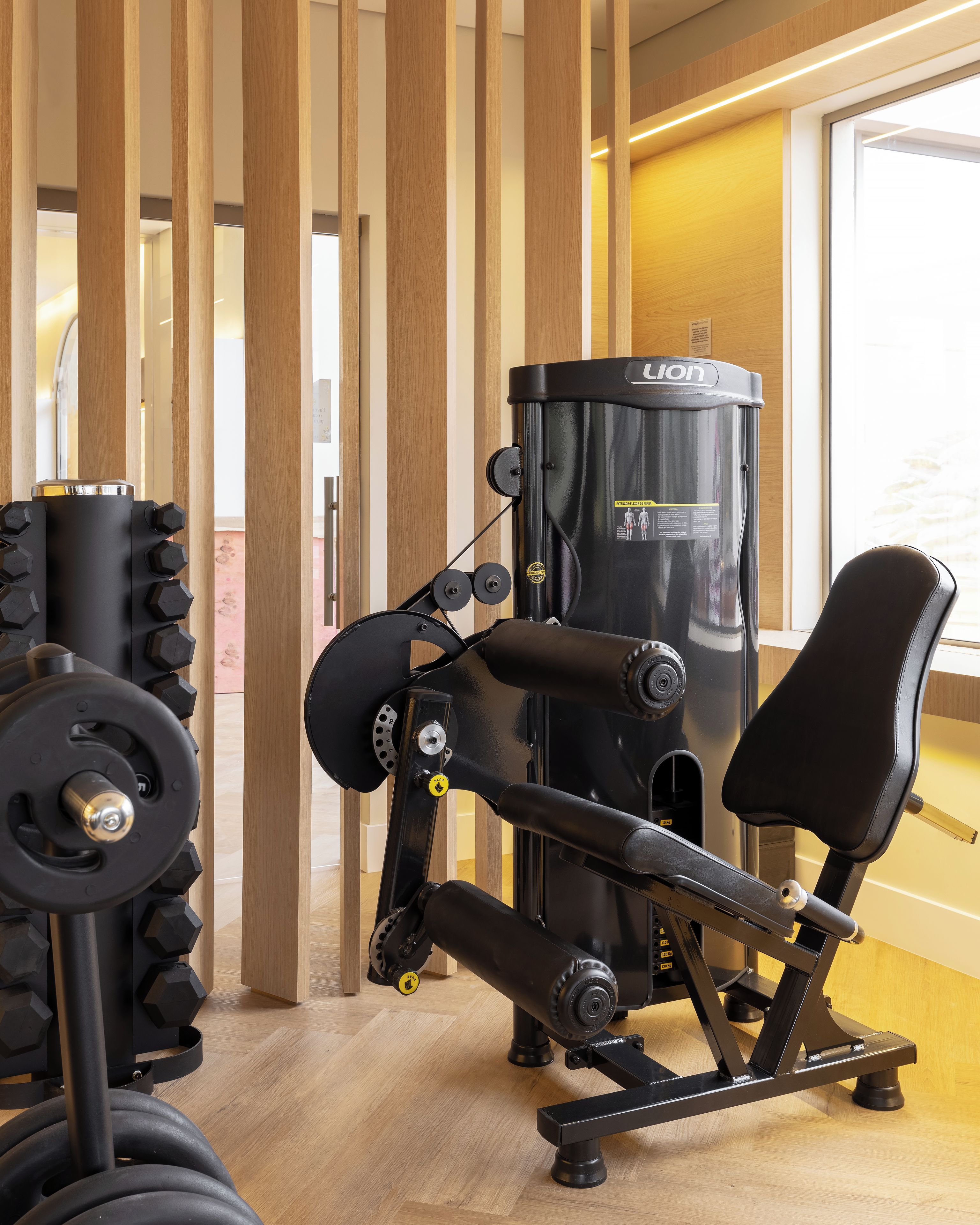 Un gimnasio con equipo de ejercicio, que incluye una máquina de pesas y una banca.