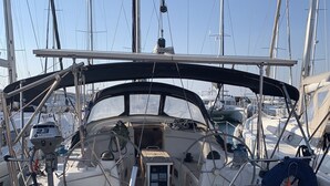 Eine Segelyacht liegt in einer Marina festgemacht, mit einer Steuerung, Winden und einem Rettungsring.