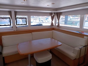 A cabin with a corner seating area, a table, and windows with curtains.