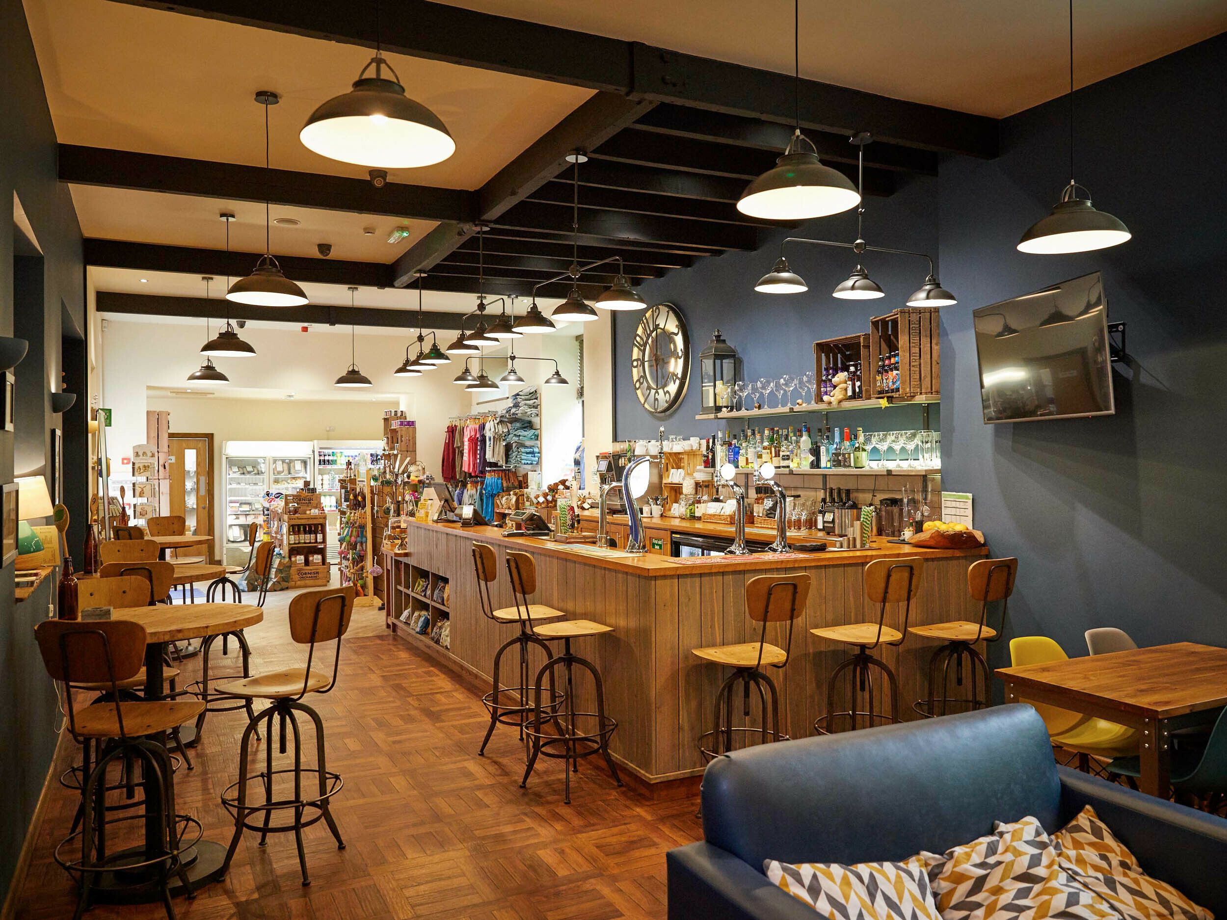 A bar area with stools, a counter, and a blue sofa.