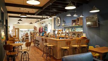 A bar area with stools, a counter, and a blue sofa.