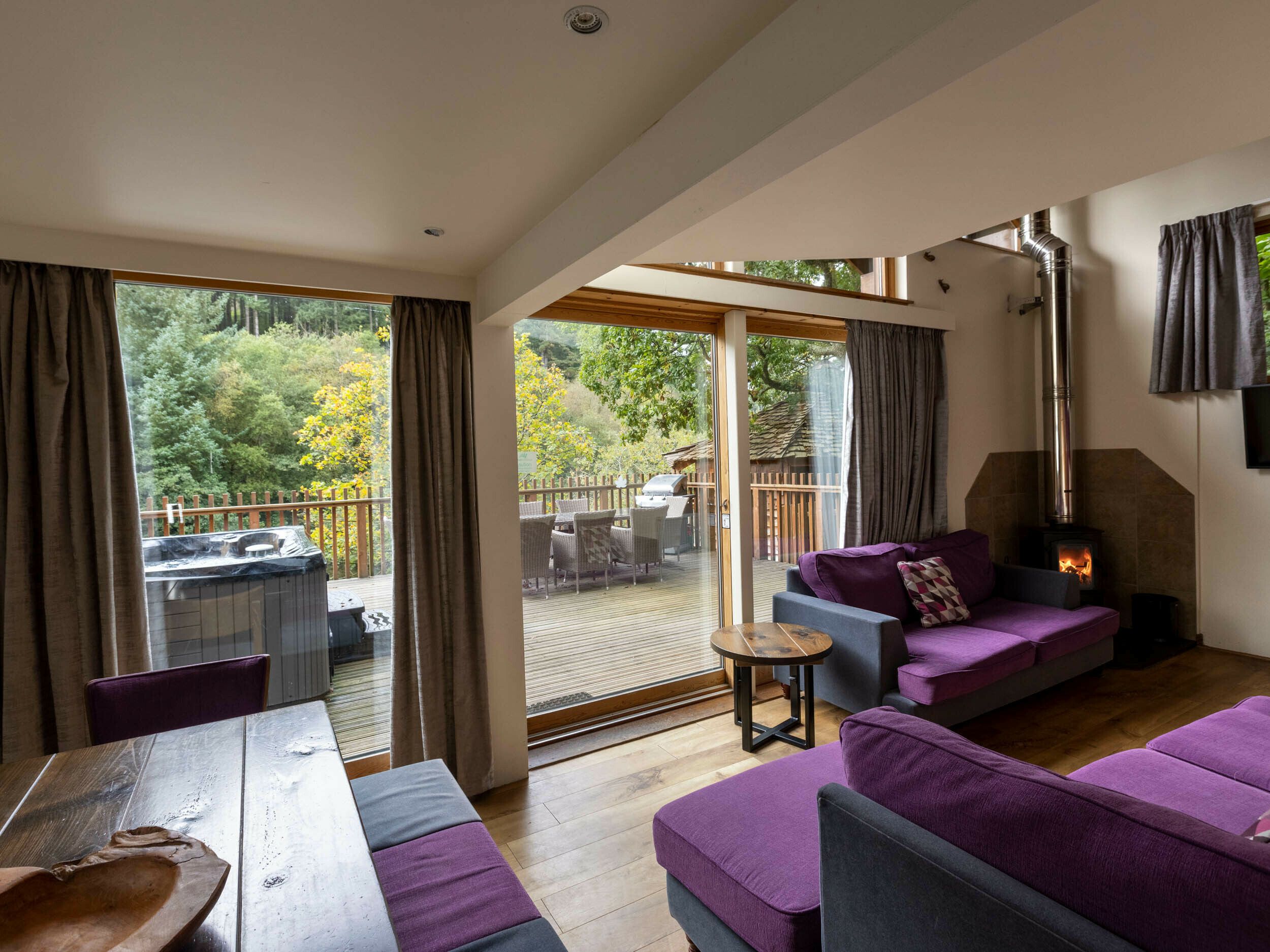A modern living room with a sofa, a table, and a fireplace.