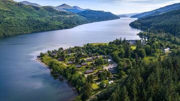 A lakeside property with a cluster of houses, a dock, and a forested area.