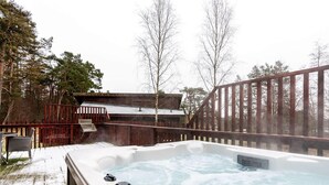 Un jacuzzi con controles, una terraza de madera y una cerca de madera.