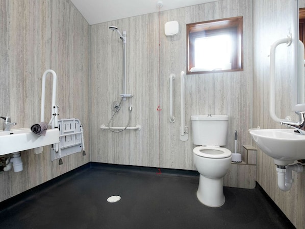 A modern bathroom with a shower, toilet, and sink.