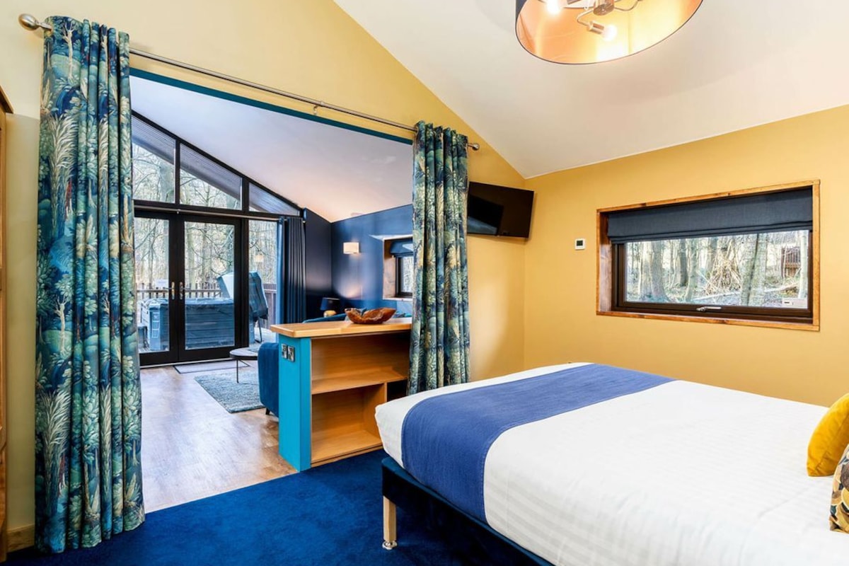 Un dormitorio con cama, escritorio y ventana.