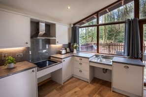 Cozinha moderna com uma janela ampla, piso de madeira e armários embutidos.