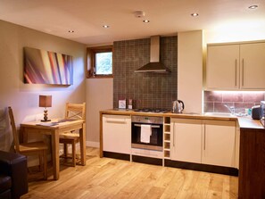 A modern kitchen with wooden cabinets, a gas stove, a microwave, and a dishwasher.